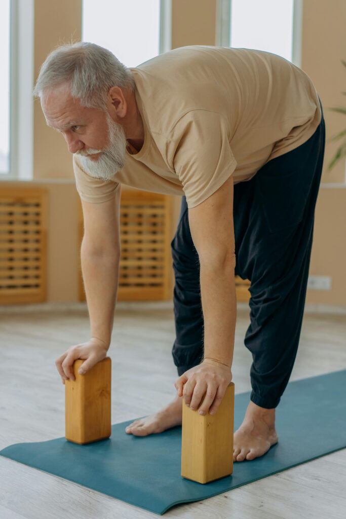 man bent over and stretching with two blocks