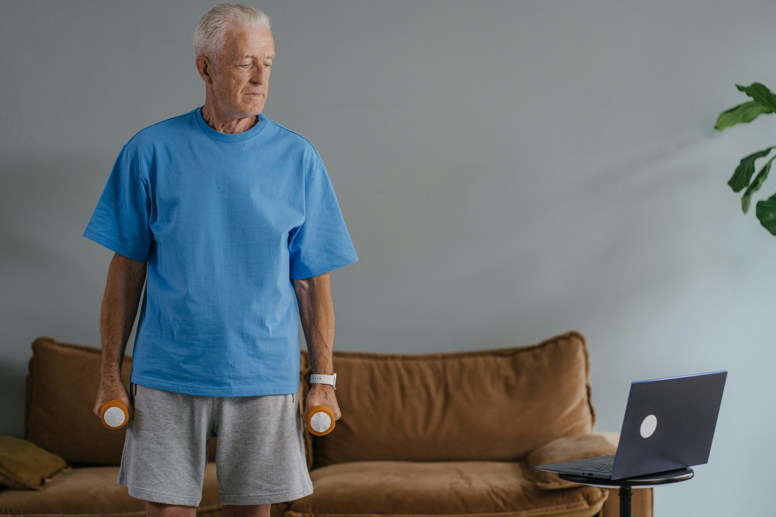 man looking at laptop while weightlifting